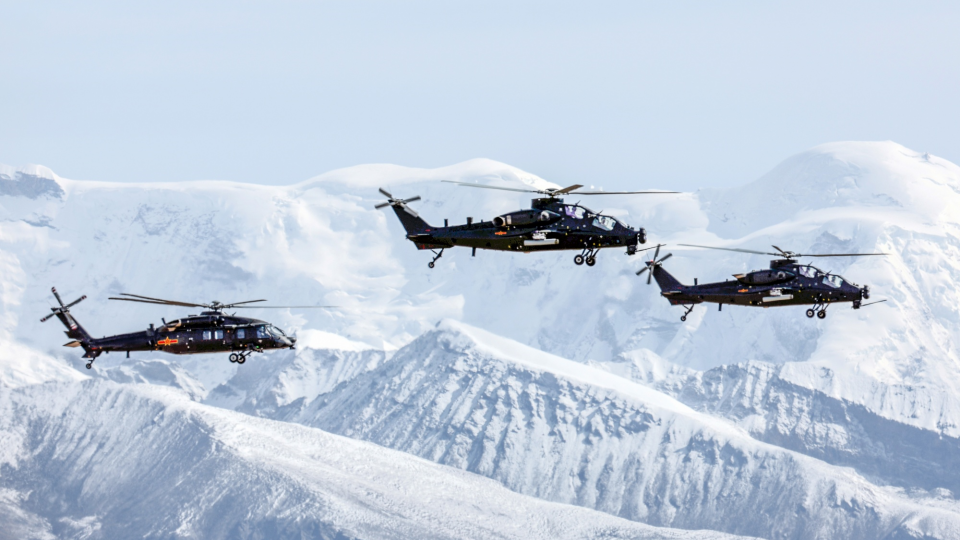 Helicopters fly in mountainous plateau area